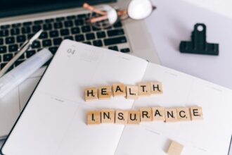Personne consultant des documents sur l'assurance santé avec un ordinateur portable