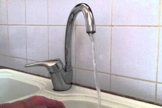robinet mélangeur qui fuit avec des gouttes d'eau visibles