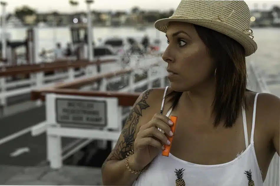 une femme avec une cigarette électronique à la main